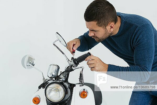 Vorderansicht junger Mann repariert Motorrad