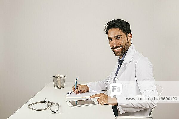 Glücklicher Arzt mit Tablettenbüro