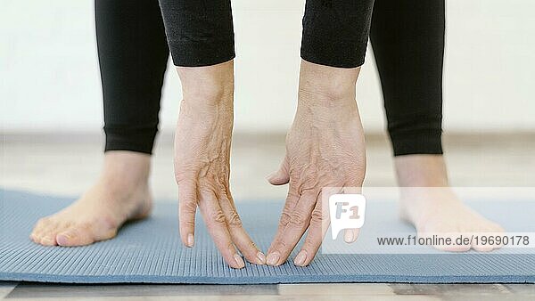 Nahaufnahme Hände berühren Yogamatte