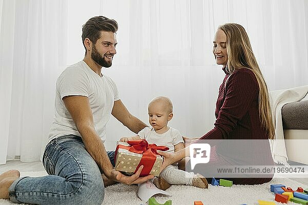 Seitenansicht Eltern zu Hause mit ihrem Babygeschenk