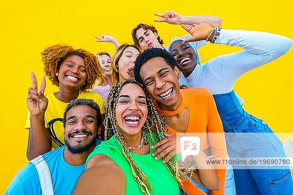 Happy multirassischen Menschen  die ein Selfie lächelnd zusammen in einem gelben Hintergrund