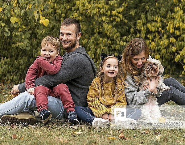 Glückliche Familie mit Hund im Freien