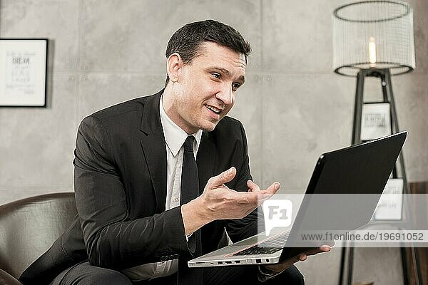 Erwachsener lächelnder Geschäftsmann beim Surfen auf seinem Laptop