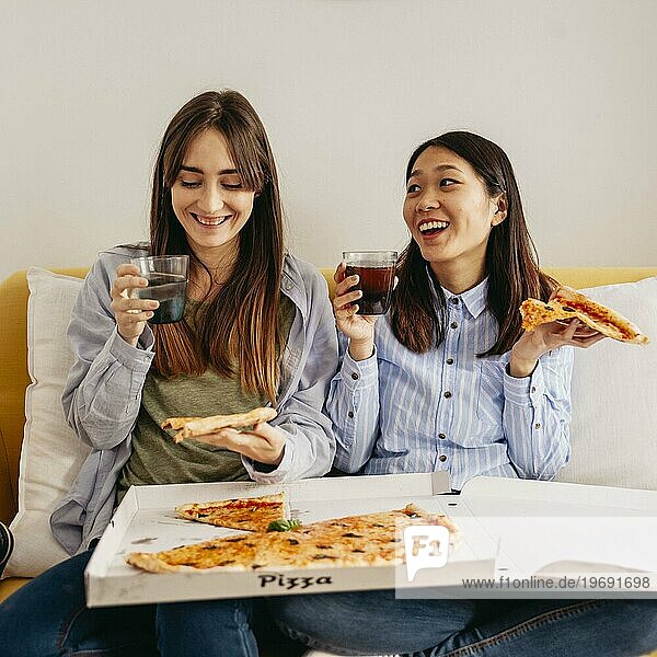 Lachende  entspannende Mädchen beim Pizzaessen