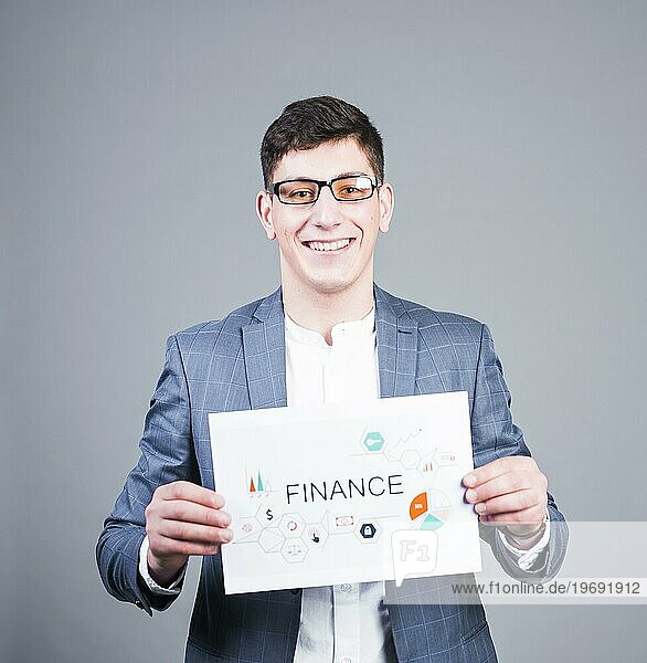 Geschäftsmann hält Papier mit Finanzaufschrift lächelnd