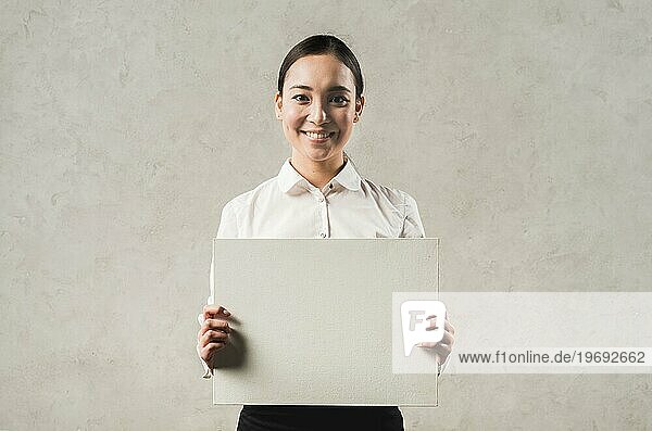 Porträt lächelnd junge asiatische Geschäftsfrau zeigt leere Plakat