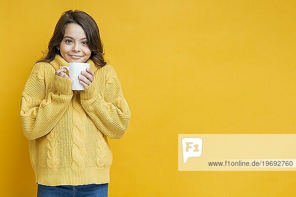 Mädchen gelber Pullover mit Tasse Hände