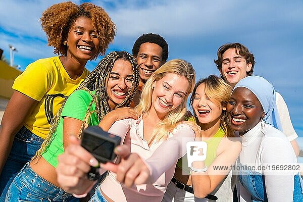 Frontalaufnahme eines multiethnischen Freundes  der ein Selfie mit einer Gopro Kamera macht