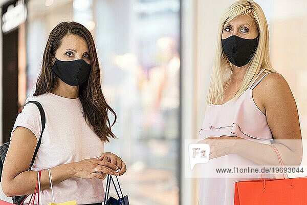Freunde tragen Stoffmasken Einkaufszentrum