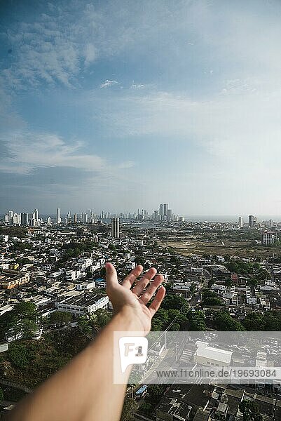 Die Hand streckt sich der Skyline der Stadt entgegen