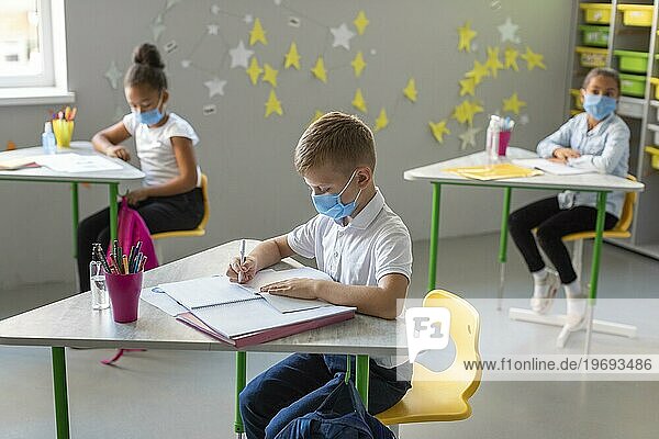 Seitenansicht Kinder  die Notizen machen  während sie medizinische Masken tragen