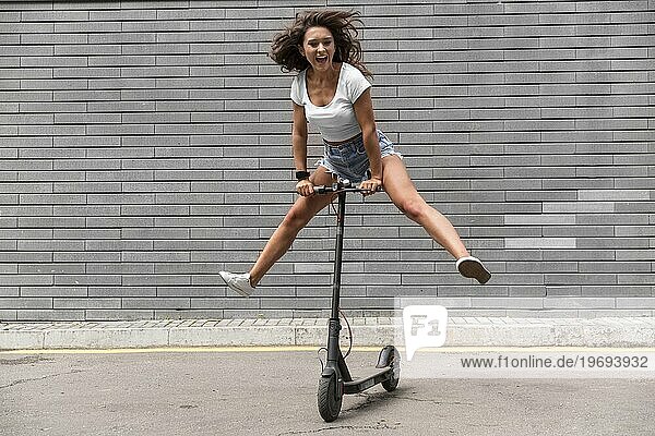 Smiley Frau hat Spaß mit Roller im Freien