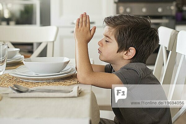 Liebenswerter Junge betet zu Hause