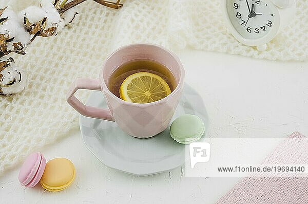 Rosa Keramiktasse mit Zitrone Tee Makronen weißen Hintergrund