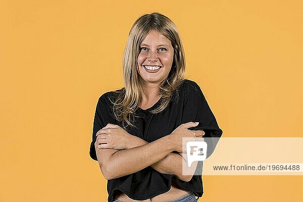 Vorderansicht lächelnde junge Frau umarmt sich selbst gelbe Oberfläche