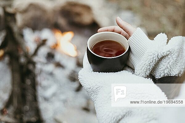 Frau hält heiße Tasse Tee im Freien