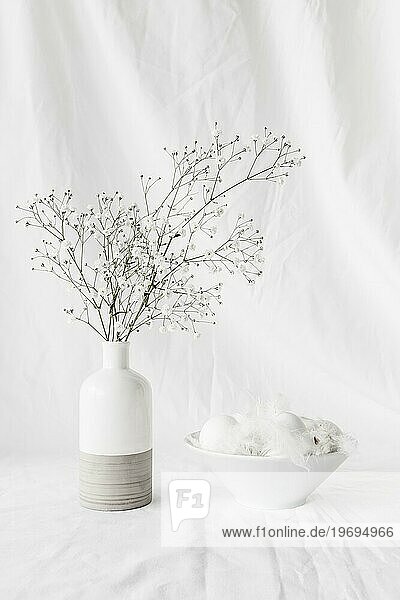 Set Ostereier Federkiele Schale in der Nähe von Pflanze Zweige Vase