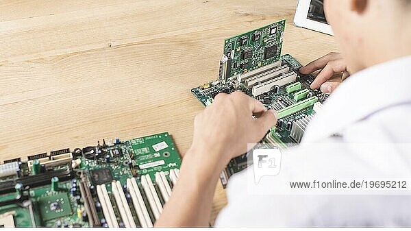 Close up männlichen Techniker reparieren modernen PC Motherboard Holztisch