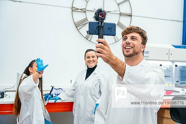 Team of scientists recording a video using phone inside a lab