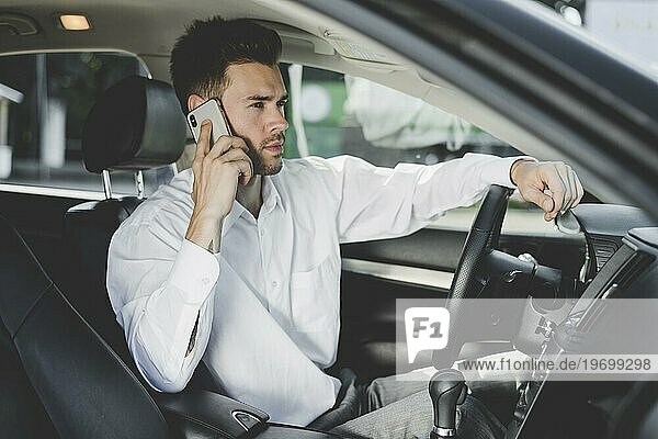 Handsome young man sitting car talking mobile phone