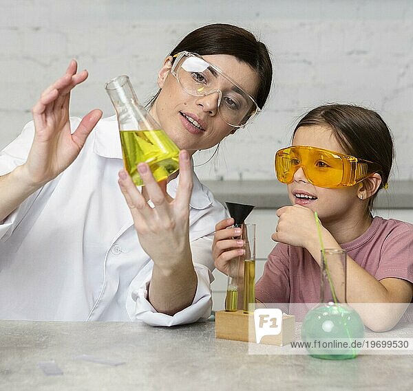 Weibliches Lehrermädchen bei wissenschaftlichen Experimenten mit Reagenzgläsern