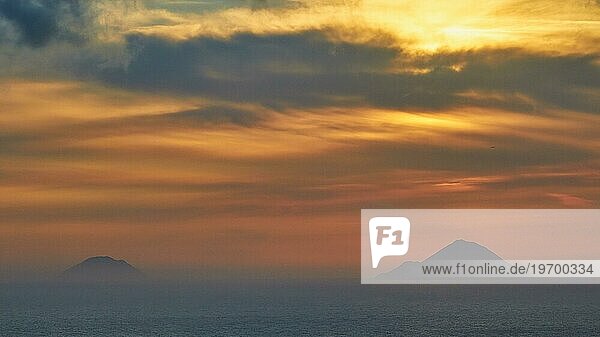 Sonnenuntergang  orangefarbener Himmel  Inseln  Alicudi  Filicudi  Graue Wolken  Lipari  Liparische Inseln  Äolische Inseln  Sizilien  Italien  Europa