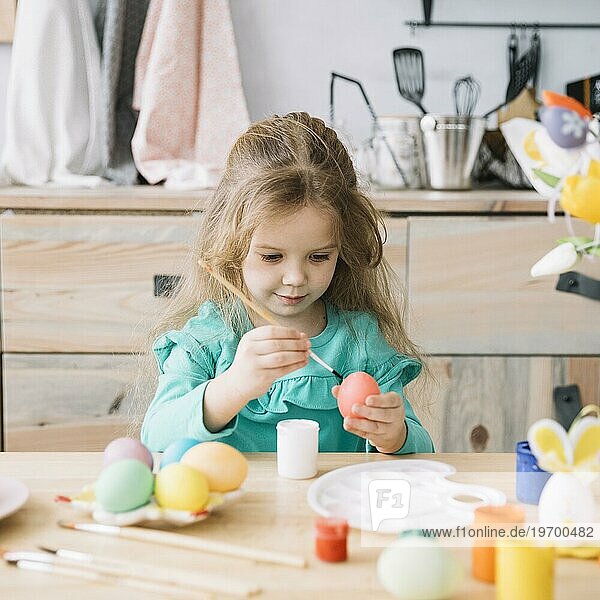 Niedliches Mädchen malt Eier zu Ostern
