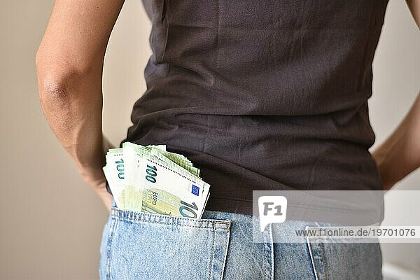 Viele einhundert Euro Geldscheine lose in der Jeans einer Frau  Symbolbild für Reichtum  Bargeld oder Verschwendung