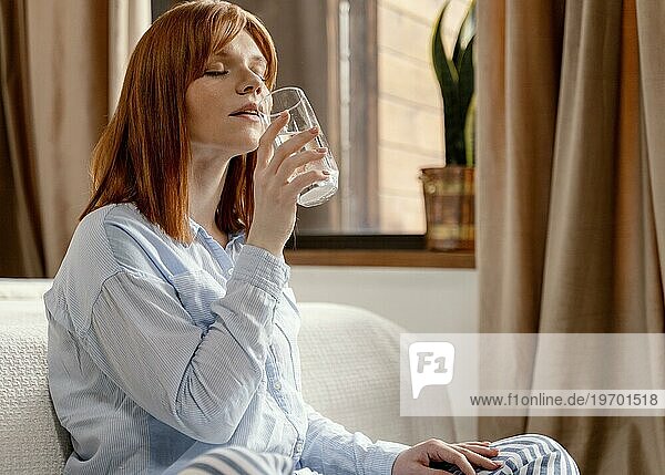 Porträt Frau zu Hause trinkt Glas Wasser