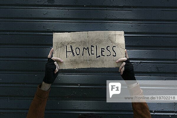 Obdachlosenschild in den Händen eines Bettlers