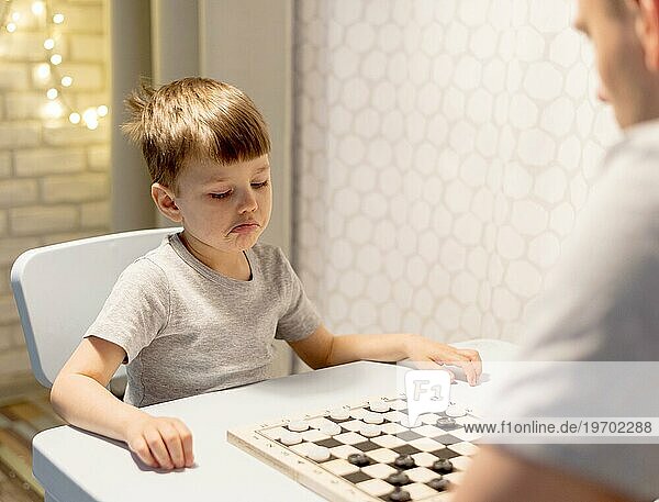 Kind spielt Schach mit Mann