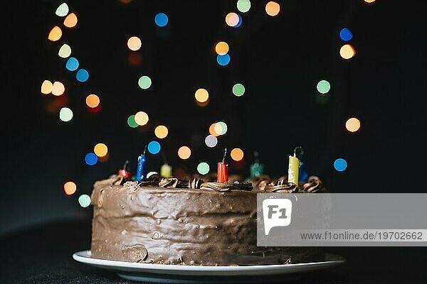 Schokoladenkuchen gegen Glitter Bokeh Lichter schwarzen Hintergrund