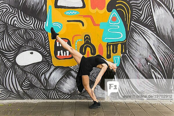 Tangotänzerin posiert vor kreativer Graffitiwand