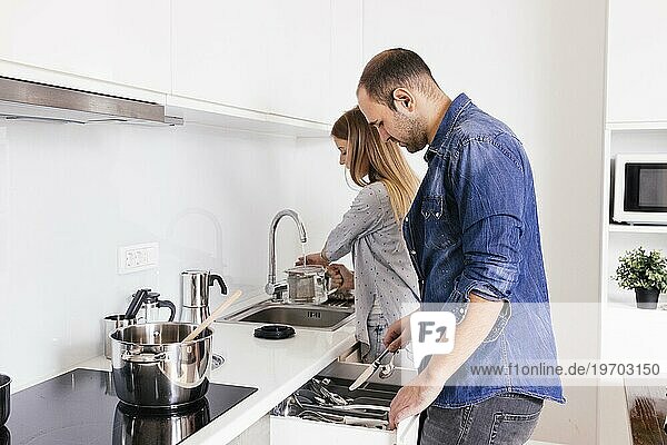 Junges Paar bei der Arbeit mit Küchenutensilien