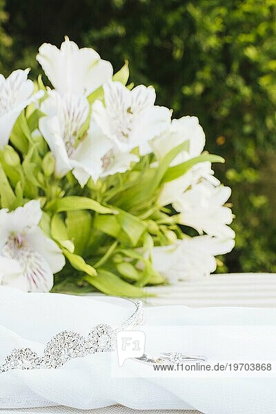 Zwei Eheringe Krone Schal mit schönen Blumenstrauß Tisch