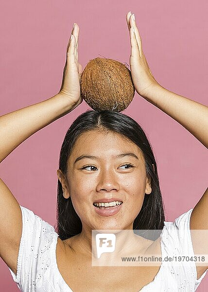 Frau hält Kokosnuss ihren Kopf