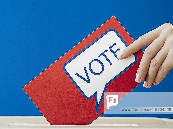 Frau legt ihren Stimmzettel in die Wahlurne
