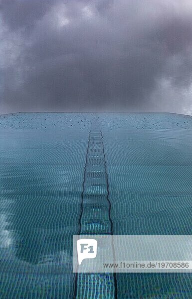 Gekräuselte Wasseroberfläche bei Regen im Schwimmbad mit dramatischer Wolkenhimmel  Österreich  Europa