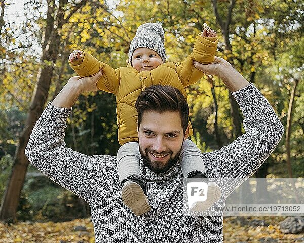 Glücklicher Mann mit seinem Kind im Freien