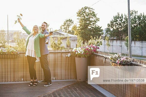 Porträt glückliches Paar hält Weinglas Rose posiert Balkon