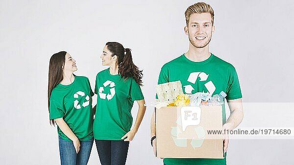 Lächelnde Frauen glücklicher Mann hält Karton mit recycelten Gegenständen