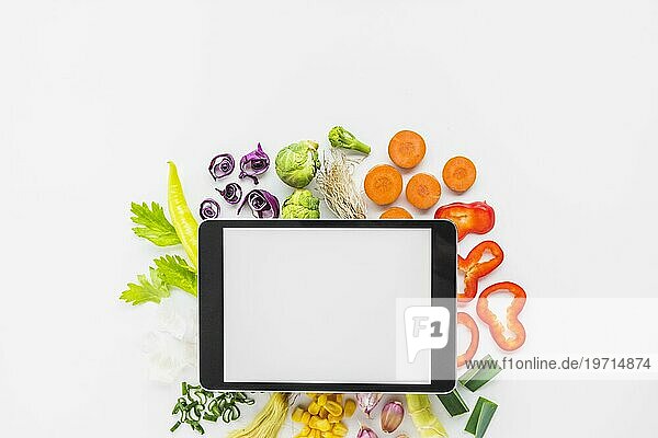 Erhöhte Ansicht digitale Tablette gehackt Gemüse weißem Hintergrund