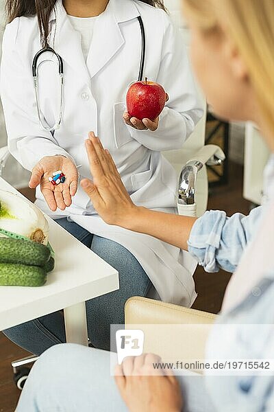 Nahaufnahme Arzt vergleicht Früchte Pillen