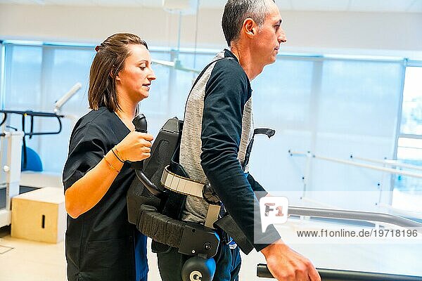 Mechanisches Exoskelett. Weibliche Physiotherapie medizinische Assistentin hilft behinderten Menschen mit Roboterskelett zu gehen. Futuristische Rehabilitation  Physiotherapie in einem modernen Krankenhaus