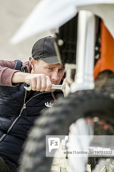 Portrait Mann versucht Motorrad zu reparieren