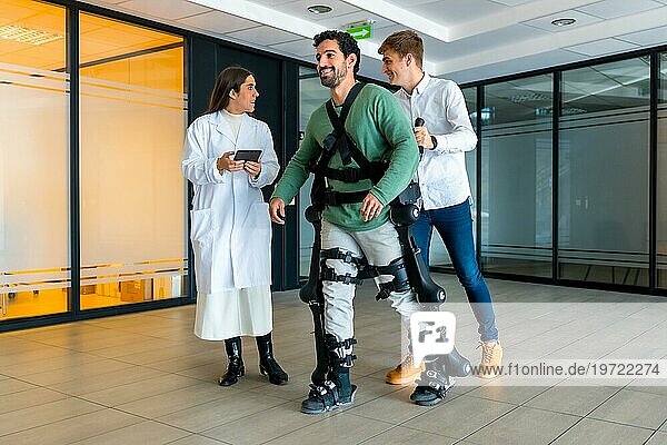 Mechanisches Exoskelett  Ärztin mit Gerät geht mit behinderter Person mit Roboterskelett in der Rehabilitation  Physiotherapie in modernem Krankenhaus  futuristische Physiotherapie