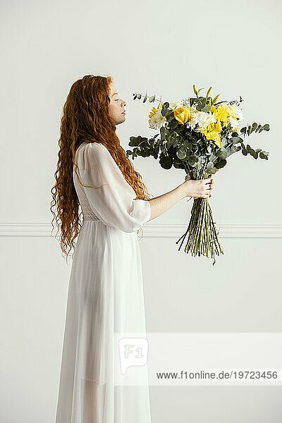 Seitenansicht Frau posiert mit Strauß Frühlingsblumen