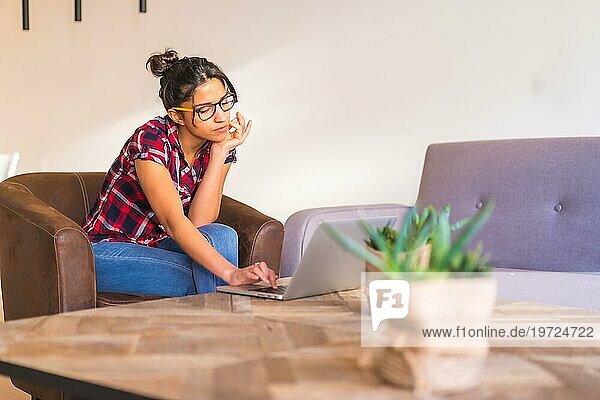Fokus auf eine junge Geschäftsfrau  die von zu Hause aus mit einem Laptop arbeitet