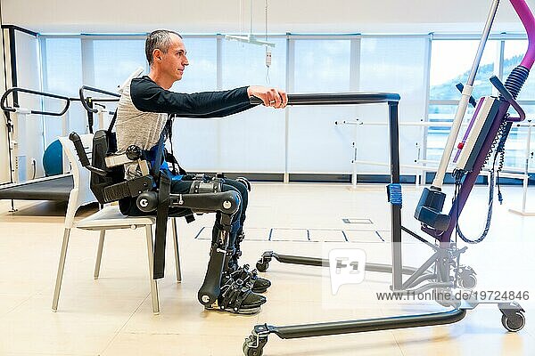 Mechanisches Exoskelett. Behinderte Person mit Roboterskelett in der Rehabilitation  die versucht  alleine aufzustehen  Physiotherapie in einem modernen Krankenhaus