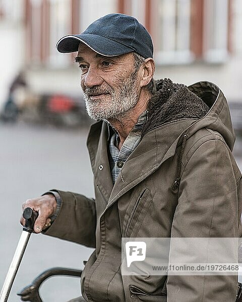 Seitenansicht Obdachloser Mann im Freien mit Gehstock